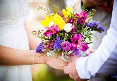 The bride and groom hold hands