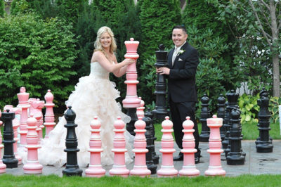 Bride and groom holding giant chess pieces