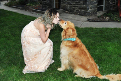 Girl in a dress kissing a dog